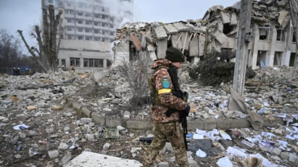 A military person walking infront of the destroyed building